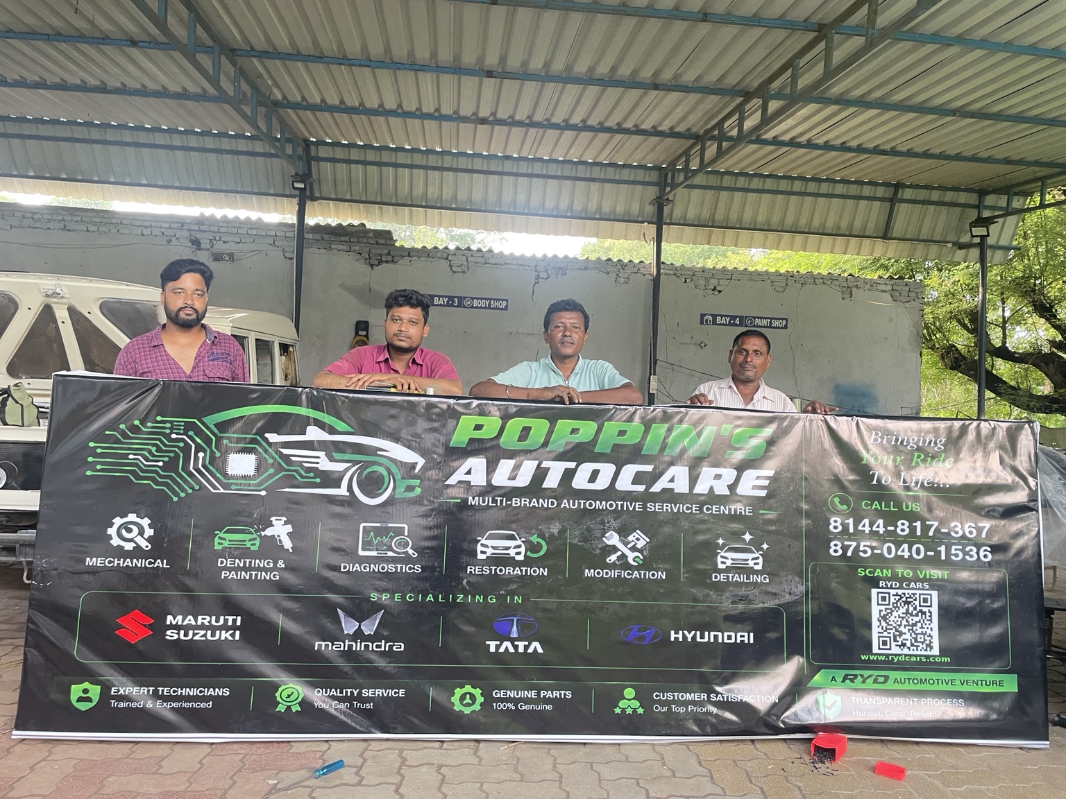 Poppin’s AutoCare team and service banner inside the Balliguda workshop